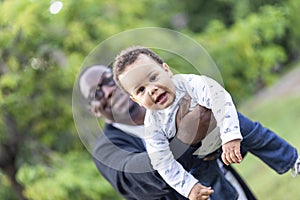 Father cuddling adorable biracial baby boy