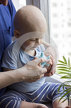 Father with cute baby boy toddler which hold blue massage ball.