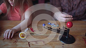 Father and cute child make a model of the solar system in the room.