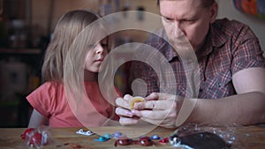 Father and cute child make a model of the solar system in the room.