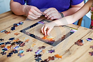 Father and daughter assemble the puzzle while sitting at the table. Games during rain and bad weather, quarantine. Family relaxing