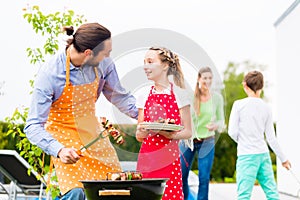 Father and daughter barbecue together