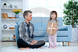 Father and daughter or brother and sister with a gift in the interior of the room. Father`s day holiday concept, Children`s Day