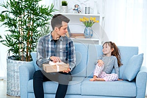 Father and daughter or brother and sister with a gift in the interior of the room. Father`s day holiday concept, Children`s Day