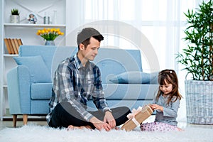 Father and daughter or brother and sister with a gift in the interior of the room. Father`s day holiday concept, Children`s Day