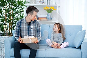 Father and daughter or brother and sister with a gift in the interior of the room. Father`s day holiday concept, Children`s Day