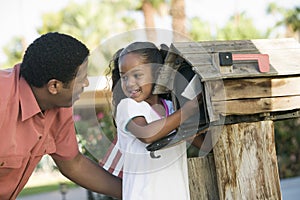 Father and Daughter checking mail at domestic Mailbox photo