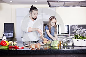 Father and daughter cooking meal together