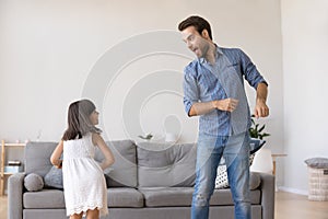 Father and daughter dancing together in living room