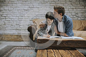 Father and  daughter doing homework at home