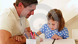 Father and daughter drawing together at the table