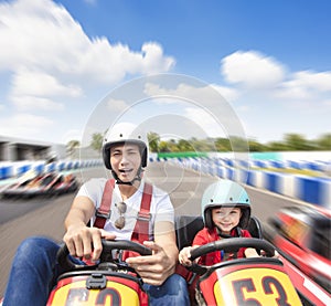 Father and daughter driving go kart on the track