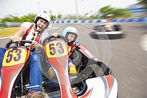 Father and daughter driving go kart on the track