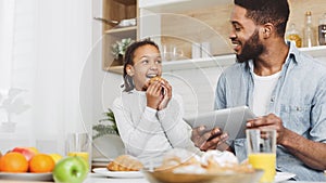 Father and daughter eating sweets and looking for new recipes