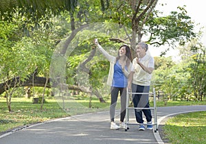 father and daughter enjoy walking in the park, senior man walking with walker