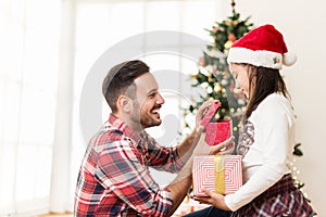 Father and daughter exchanging and opening Christmas presents