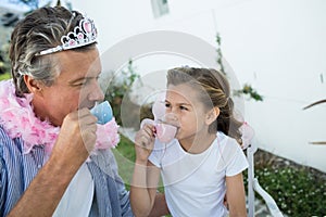 Father and daughter in fairy costume having a tea party