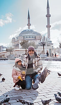father and daughter feeding the bird together in taksim square photo