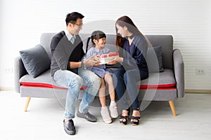 Father and daughter are giving birthday gifts to mothers in the living room.