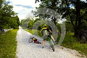 Father and daughter going in bicycle. Little girl falling off her bicycle