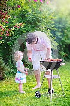 Father and daughter grilling in the garden