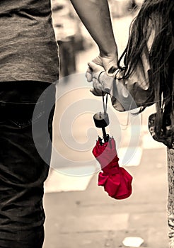 Father and daughter hand in hand with red umbrella