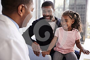 Father And Daughter Having Consultation With Female Pediatrician In Hospital Office photo