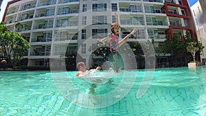 Father and daughter having fun in swimming pool. Slow motion video