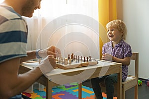 father and daughter having fun together learning to play chess