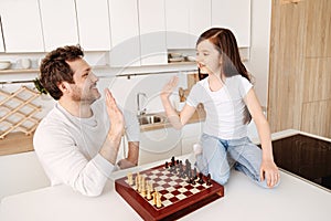 Father and daughter high-fiving each other after chess game