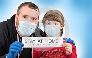 Father and daughter holding poster `Stay at home` message photo