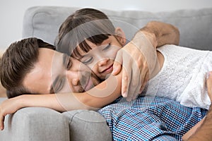 Father and daughter hugging lying on sofa