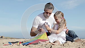 Father and Daughter With a Kite on the Beach