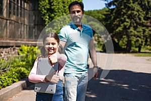 Father with daughter with laptop in park