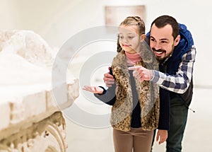 Father and daughter looking at ancient bas-reliefs in museum