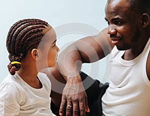 Father and daughter looking into each other`s eyes over blue