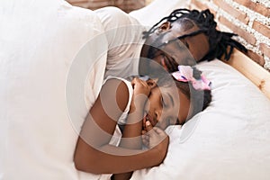 Father and daughter lying on bed sleeping at bedroom