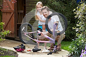 Father And Daughter Mending Bike Together