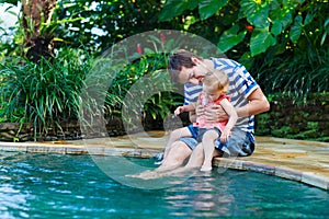 Father and daughter near swimming pool