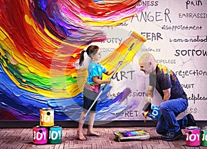 Father and daughter paint on the wall