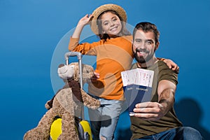 father and daughter with passports and tickets going on vacation