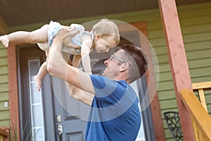 Father and daughter play in front of the house