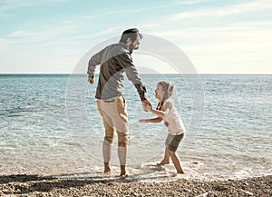 Father and daughter playing on the beach in Pula Croatia