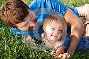 Father And Daughter Playing In Grass