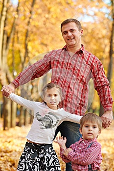 Father and daughter are playing and having fun in autumn city park. They posing, smiling, playing. Bright yellow trees