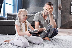 Father and daughter playing with joysticks