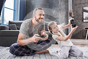Father and daughter playing with joysticks