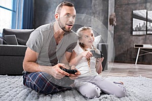 Father and daughter playing with joysticks