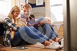 Father and daughter playing with pet cat