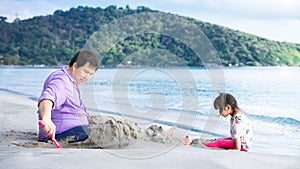 Father and daughter are playing in the sand on the beach. Family was having fun.